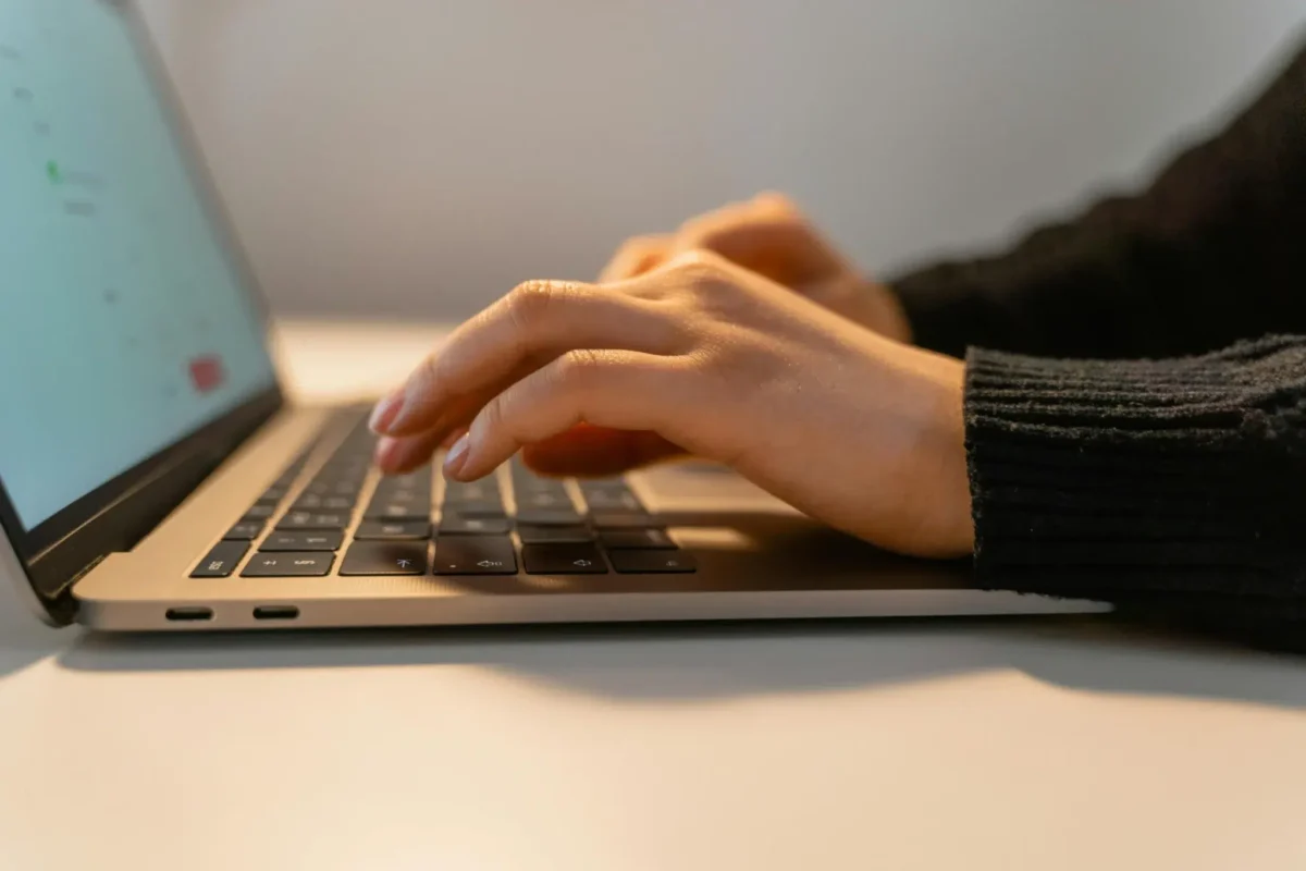 A person types on a laptop in a clean workspace, symbolizing Clean Data for Automation, driving accuracy and efficiency in digital workflows through streamlined input and reliable systems.