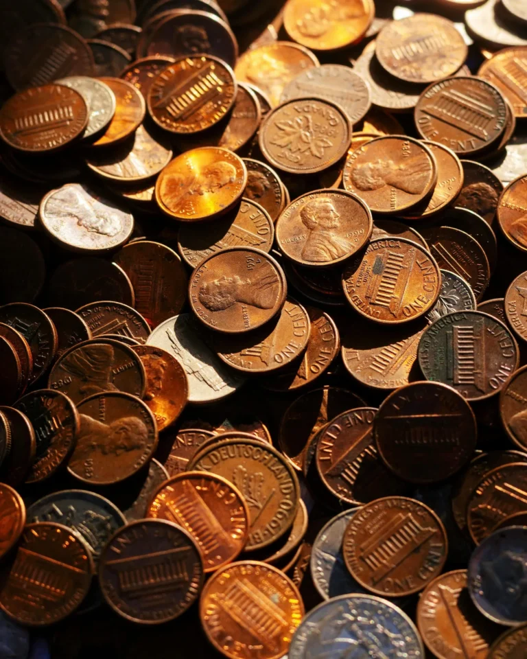 A pile of penny coins in varying shades of copper represents the farewell to penny coins, highlighting the economic debate, nostalgia, and repurposing in U.S. currency policy.