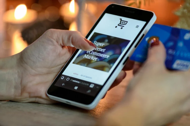 A person shops online using a smartphone and credit card, symbolizing Fintech Growth Strategies that scale innovation and funding through mobile commerce, digital payments, and consumer-driven financial technology.