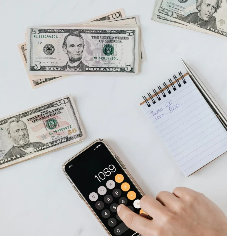 Business owner calculates expenses with cash and a notepad during the SBA loan government shutdown.