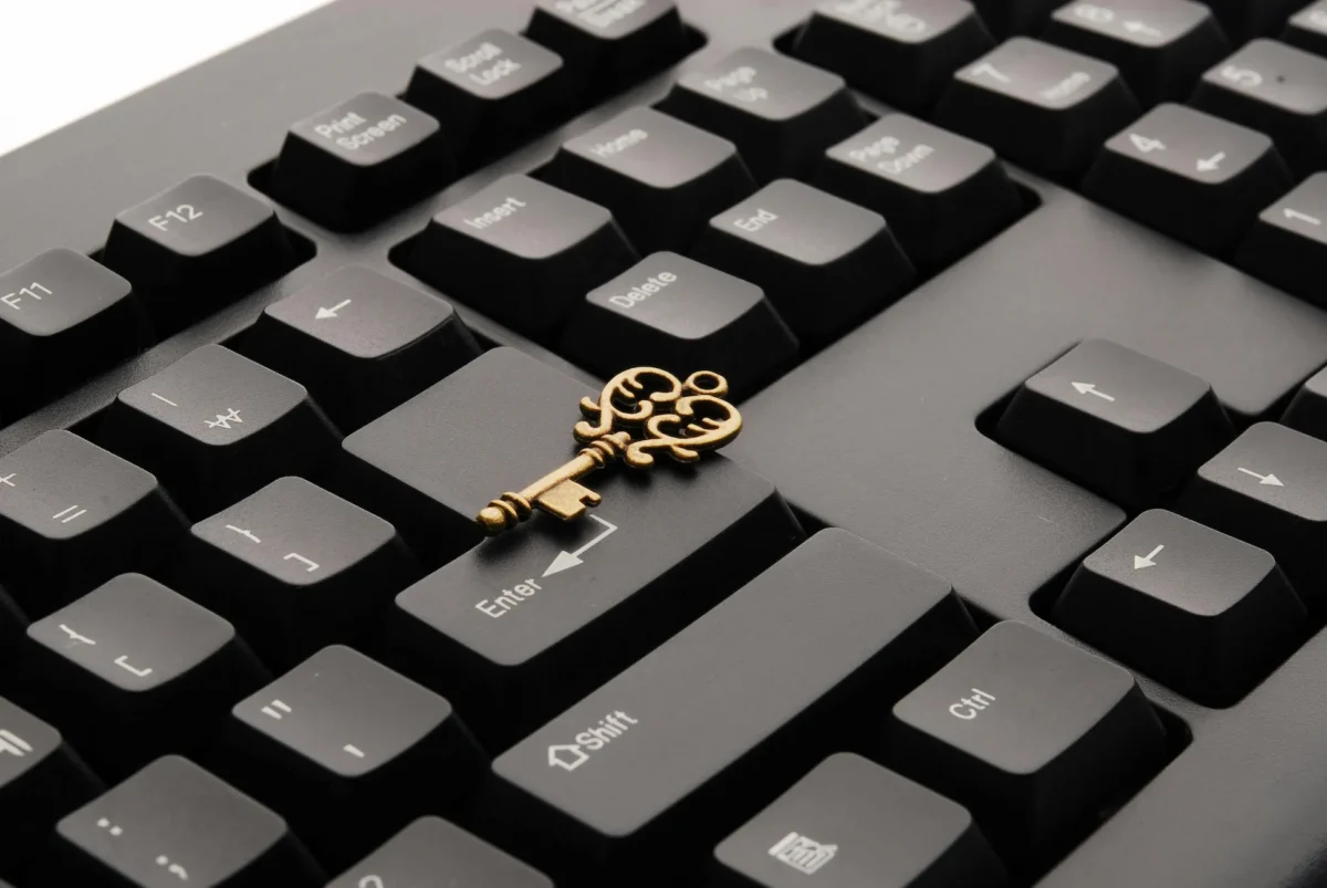 A vintage key rests on a modern keyboard’s Enter key, symbolizing Cybersecurity Brand Visibility in a digital market through the fusion of legacy trust symbols and contemporary tech, highlighting secure access and brand recognition.