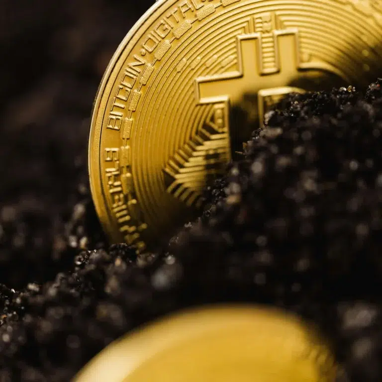 A golden Bitcoin coin partially buried in dark soil, symbolizing Fintech Digital Transformation for Modern Financial Growth through the emergence of decentralized assets, blockchain innovation, and the evolving role of cryptocurrency in reshaping global financial ecosystems.