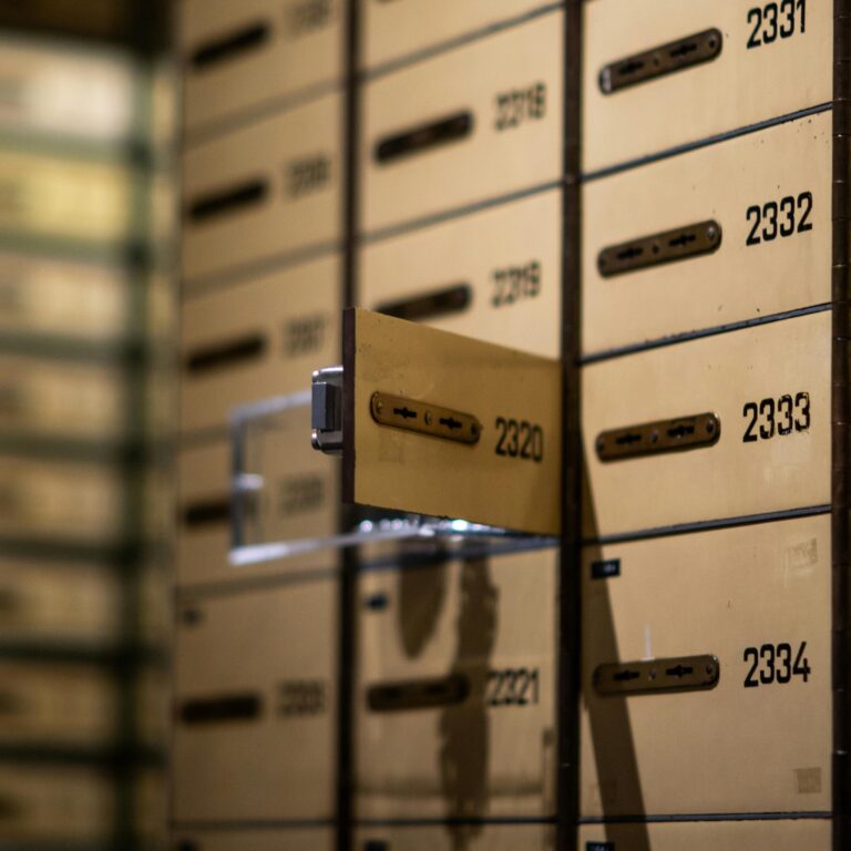 A partially open safe deposit box among a grid of numbered vault compartments in a financial institution, symbolizing Saving Plan Financing Strategies for Wealth Growth through secure asset storage, long-term financial planning, and institutional tools that protect and grow personal wealth.