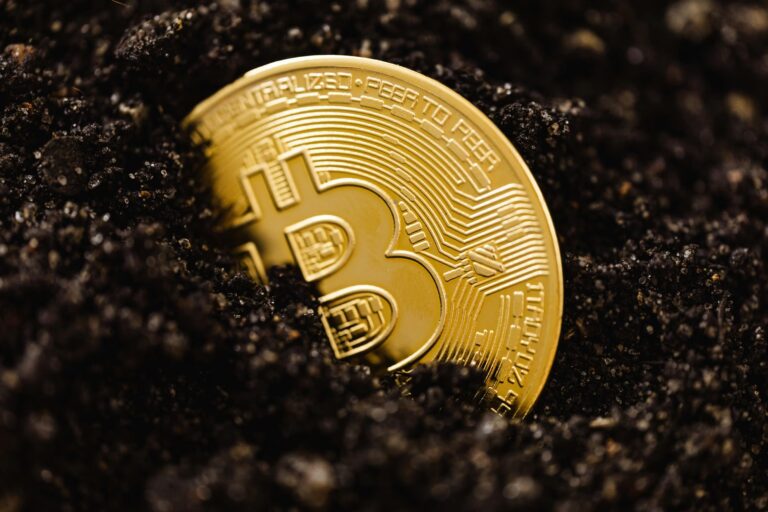 A gold-colored Bitcoin coin engraved with circuit patterns and the words “DECENTRALIZED • PEER TO PEER” lies partially buried in dark soil, symbolizing Beyond Digital Gold Mastering Bitcoin Innovation Trends in 2026 through the emergence of decentralized finance, tokenized infrastructure, and cryptographic trust systems that redefine digital value, economic sovereignty, and innovation in the global financial landscape.