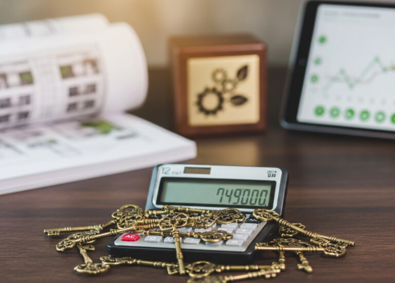 A workspace features an open book with financial charts, a calculator displaying “749,000” topped with vintage keys, a wooden block with a gear and leaf design, and a tablet showing an upward-trending line graph with green data points,symbolizing Business Mortgage Rate Insights for Sustainable Financing through strategic analysis, capital unlocking, and founder-led financial planning that empower businesses to evaluate mortgage options, align borrowing with growth goals, and build resilient funding models for long-term sustainability.