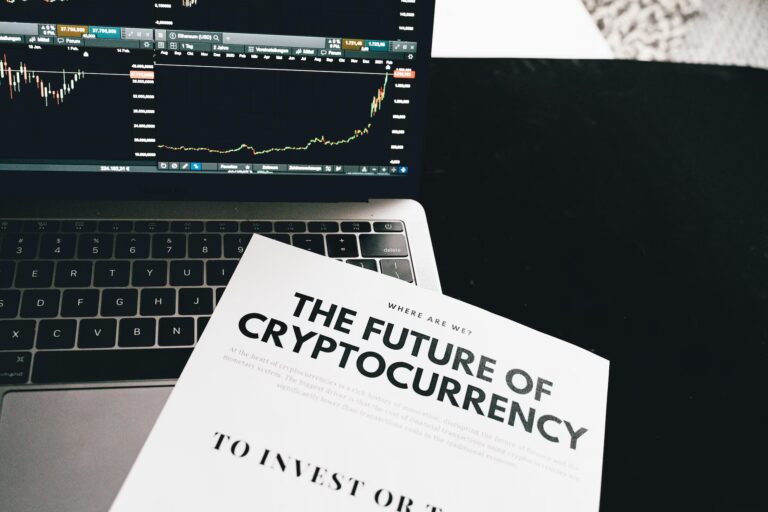 A laptop displays cryptocurrency price charts for Bitcoin and Ethereum with candlestick patterns and market data, while a printed magazine titled “THE FUTURE OF CRYPTOCURRENCY” lies in front, symbolizing Crypto News Global Adoption Insights through real-time trading platforms, investor analysis, and media narratives that empower founders and global stakeholders to track digital asset trends, assess adoption signals, and navigate the evolving crypto-finance landscape.