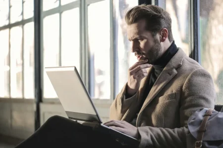 A person in a modern workspace concentrates on a laptop, symbolizing AI-Driven Stock Market Analysis for smarter investing through data-powered insights, predictive modeling, and real-time decision support.