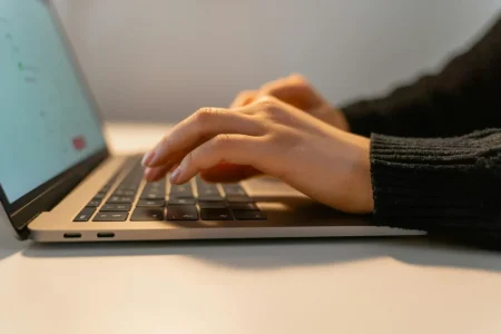 A person types on a laptop in a clean workspace, symbolizing Clean Data for Automation, driving accuracy and efficiency in digital workflows through streamlined input and reliable systems.