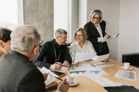 A team of professionals collaborates around a conference table with charts and graphs, symbolizing an Industry Scaling Roadmap to expand operations and sustain growth through strategic planning, data-driven decisions, and cross-functional alignment.