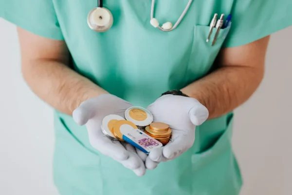 A medical professional in scrubs holds Euro coins and a 500 Euro bill, symbolizing Wellness Business Loans that fund health entrepreneurs through accessible capital and financial empowerment in the healthcare sector.